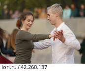 Moscow, Russia - May 9, 2022: Cheerful Dancing couple of young man and woman in public park. Lifestyle theme. Having fun people. People celevrate Victory Day, the win in the Great Patriotic War. Редакционное фото, фотограф YuryKara / Фотобанк Лори