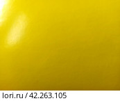 Beautiful bright yellow background. Close-up sheet of shiny reflective incident light paper. Pure fun color. Intense shade of yellow, close to gold or sunny with high reflectivity. Стоковое фото, фотограф Юлия Петровская / Фотобанк Лори