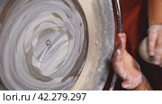 A woman's hands knead a lump of white clay over a potter's wheel. Preparing the raw material for work on a mug or other product. Close-up. The concept of handicraft, art and craft. Vertical video. Стоковое видео, видеограф Воловодов Владимир / Фотобанк Лори