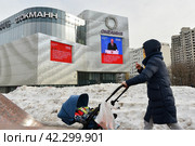 Трансляция ежегодного послания президента РФ Владимира Путина к Федеральному Собранию на медиафасаде торгового центра Океания в Москве (2024 год). Редакционное фото, фотограф AK Imaging / Фотобанк Лори