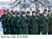 Maykop, Russia - January 13, 2024: young soldiers artillerymen in green dress uniforms with Kalashnikov assault rifles stand in formation on the parade ground on a winter morning. Редакционное фото, фотограф Андрей С / Фотобанк Лори