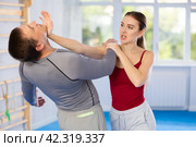 Woman hits man attacker on head during self defense training session. Стоковое фото, фотограф Яков Филимонов / Фотобанк Лори