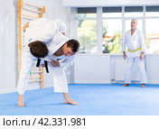 Experienced karate instructor demonstrating techniques in sparring with young fighter. Стоковое фото, фотограф Яков Филимонов / Фотобанк Лори