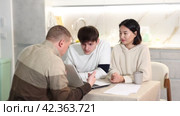 Experienced male agent offers to issue an insurance policy or take out a financial loan for spouses at home. Стоковое видео, видеограф Яков Филимонов / Фотобанк Лори