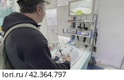 Man in cap using forceps of laparoscopic simulator box (2024 год). Редакционное видео, видеограф Антон Гвоздиков / Фотобанк Лори
