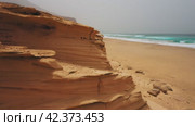 Drone flight over endless sand beach Cofete. Volcanic mountain landscape. Golden sandstones in sunset warm light. Ocean water evaporation. Dust, mist, fog rises above the waves. Fuerteventura Island. Стоковое видео, видеограф Igor Tichonow / Фотобанк Лори