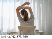Faceless young female working from home and feeling discomfort i. Стоковое фото, фотограф Natalia Gdovskaia / Фотобанк Лори