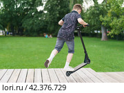 Moscow, Russia - July 26-2019 Trick at sportive push scooter in the park. Редакционное фото, фотограф YuryKara / Фотобанк Лори