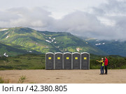 Пластиковые туалетные кабинки в горах. Зона отдыха на перевале. Туристическая инфраструктура. Путешествия и туризм на Камчатке. Камчатский край, Дальний Восток России. (2022 год). Редакционное фото, фотограф Андрей Степанов / Фотобанк Лори