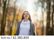 Красивая женщина со светло-каштановыми волосами. Портрет девушки в элегантном сером пальто. Молодая женщина гуляет в осеннем парке. Стоковое фото, фотограф Андрей Степанов / Фотобанк Лори