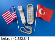 USA, Turkey flag and old corded telephone on a blue background, concept on the theme of telephone conversations between countries. Стоковое фото, фотограф Сергей Чайко / Фотобанк Лори