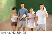 Two happy couples after playing paleta fronton on tennis court. Стоковое фото, фотограф Яков Филимонов / Фотобанк Лори