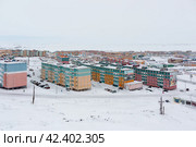 Город Анадырь, Чукотка, Россия. Зимний вид сверху на заснеженный северный город в Арктике. На красочных зданиях развешаны баннеры с текстами «Мы здесь живем!», «Мы растем!». Редакционное фото, фотограф Андрей Степанов / Фотобанк Лори