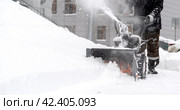 snowblower removes snow, a man cleans the yard outside. Стоковое фото, фотограф Igor Skripachev / Фотобанк Лори