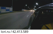 Автомобиль едет по ночной автостраде. Вид сзади со стороны автомобиля. Дорога освещена уличными фонарями. Гиперсветовые полосы. Автомобиль обгоняют другие машины. Ночная поездка. Россия 1 апреля 2023 года. Редакционное видео, видеограф Воловодов Владимир / Фотобанк Лори