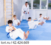 Teenagers performing core twist with simultaneous punches during martial arts training. Стоковое фото, фотограф Яков Филимонов / Фотобанк Лори