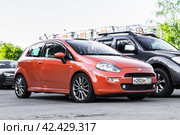 Orange Fiat Grande Punto three door hatchback parked on the street in the city. Front side view (2021 год). Редакционное фото, фотограф Константин Григорьев / Фотобанк Лори