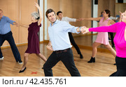 Man practicing jitterbug with female partner in dance studio. Стоковое фото, фотограф Яков Филимонов / Фотобанк Лори