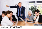 Angry elderly boss scolding subordinates at meeting in office. Стоковое фото, фотограф Яков Филимонов / Фотобанк Лори