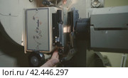 Process of charging 35mm cine-film roll in the mechanism of film projector. Hands cinema mechanic close-up. Стоковое видео, видеограф EStarodubov / Фотобанк Лори