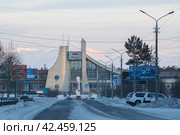 Город Северобайкальск, Республика Бурятия, Сибирь, Россия. Вид на Ленинградский проспект и железнодорожный вокзал. Станция Байкало-Амурской магистрали (БАМ) на участке, входящем в состав Восточно-Сибирской железной дороги. На фасаде здания вывеска «Вокзал». Зимняя холодная погода. (2024 год). Редакционное фото, фотограф Андрей Степанов / Фотобанк Лори