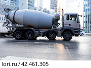 Concrete mixer truck on city street. Side view of MAN TGA cement mixer driving on urban highway. Редакционное фото, фотограф Константин Григорьев / Фотобанк Лори