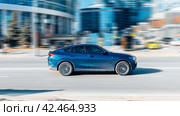 Blue BMW X6 G06 xDrive30d M Sport fast speed drive on city road. Редакционное фото, фотограф Константин Григорьев / Фотобанк Лори
