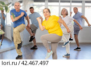 Woman participating in Zumba class for seniors in fitness studio. Стоковое фото, фотограф Яков Филимонов / Фотобанк Лори