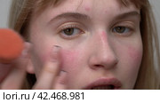 Young woman uses her finger to blend blush. Process applying blush to face with makeup brush. Стоковое видео, видеограф А. А. Пирагис / Фотобанк Лори