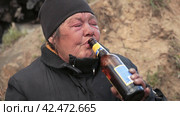 Бомж, бездомная женщина бродяга. Portrait homeless woman vagabond in a temporary place is drinking beer. Стоковое видео, видеограф EStarodubov / Фотобанк Лори