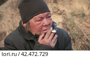 Бомж, бездомная женщина бродяга. Close up portrait homeless woman vagabond smoking a cigarette. Стоковое видео, видеограф EStarodubov / Фотобанк Лори