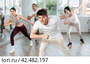 Smiling young people practicing vigorous lindy hop movements in dance class. Стоковое фото, фотограф Яков Филимонов / Фотобанк Лори