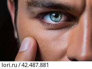 Man holding finger on contact lens closeup. Generate Ai. Стоковое AI-изображение, AI-художник Иван Рябоконь / Фотобанк Лори