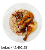 Boiled rice with vegetable gravy and piece of fried chicken is served on large white platter. Стоковое фото, фотограф Яков Филимонов / Фотобанк Лори