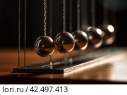 Newtons cradle wooden table circle. Generate Ai. Стоковое AI-изображение, AI-художник Иван Рябоконь / Фотобанк Лори