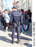 Russian policeman with gun belt, handcuffs, truncheon, shoker, gun and holster. Text in russian: Police (2018 год). Редакционное фото, фотограф FotograFF / Фотобанк Лори