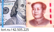 Folded american dollars banknotes with Benjamin Franklin portrait wrapped by rubber band and chinese banknote with Mao Zedong portrait. Стоковое фото, фотограф FotograFF / Фотобанк Лори