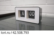 Перекидной циферблат часов будильника. Монтаж двух планов. Flip clock mechanism. 6:00 PM. Flip clock watch face. White brick wall in the background. Slow motion 240 fps. Стоковое видео, видеограф EStarodubov / Фотобанк Лори