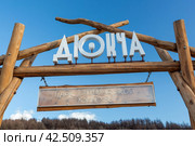 Вывеска над входом в парк с текстом «Дюкча. Парк этнической культуры». Город Магадан, Магаданская область, Россия. Туристическая достопримечательность. (2023 год). Редакционное фото, фотограф Андрей Степанов / Фотобанк Лори