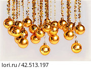 Background of tinsel. Gold spangles festoons hang. Vertical white and black lines. Holiday lights, garlands. Party, celebration, abstract and festive background textures. Foil strips, decoration. Стоковое AI-изображение, AI-художник Aleksandr Golubev / Фотобанк Лори