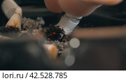 Потушить сигарету в пепельнице. Макро. Putting out cigarette in ashtray with cigarette butts. Macro shot. Стоковое видео, видеограф EStarodubov / Фотобанк Лори