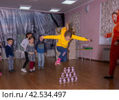 Аниматор играет с детьми из многодетных семей на праздничном мероприятии, организованном благотворительной организацией. The animator plays with children from large families at a festive event organized by a charity organization. (2021 год) Редакционное фото, фотограф Мария / Фотобанк Лори
