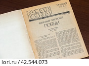 Раскрытый старинный журнал лежит на столе (2023 год). Редакционное фото, фотограф Игорь Низов / Фотобанк Лори