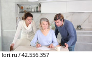 Man and woman help elderly mother make will and fill out document correctly. Стоковое видео, видеограф Яков Филимонов / Фотобанк Лори
