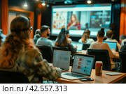 Focused diverse students using laptops and watching presentation on screen in modern classroom. Стоковое AI-изображение, AI-художник Юрий Поздников / Фотобанк Лори