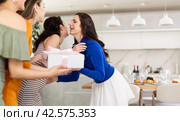 Hospitable hostess kissing female friends arriving for home get-together. Стоковое фото, фотограф Яков Филимонов / Фотобанк Лори