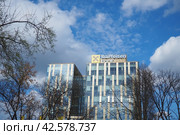Belgrade, Serbia, March 17, 2024: Raiffeisen Bank building in New Belgrade. Raiffeisen Bank International RBI is a key entity of the decentralized Raiffeisen Banking Group in Austria. Modern building. Редакционное фото, фотограф Юлия Петровская / Фотобанк Лори