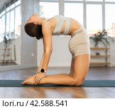 Athletic girl meditates in chandrasana pose in gym. Стоковое фото, фотограф Яков Филимонов / Фотобанк Лори