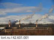 Apatity, Murmansk region, Russia, March 12, 2024: Territory of industrial area of Second apatite-nepheline concentration factory in north of city at foot of Vudyavrchorr Khibin mountain. Редакционное фото, фотограф Алексей Антипов / Фотобанк Лори