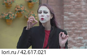 Mime young woman imitates an imaginary stirring a teaspoon of sugar and drinking from a cup of tea or coffee. Стоковое видео, видеограф EStarodubov / Фотобанк Лори